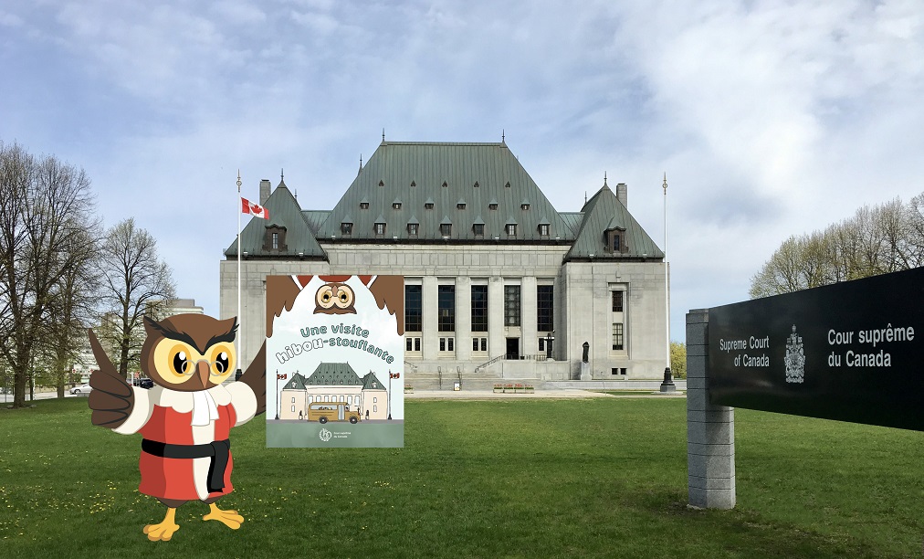 Amicus devant l’édifice de la Cour suprême avec un exemplaire d’Une visite hibou-stouflante à la main
